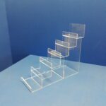 Clear acrylic display stand on blue background.