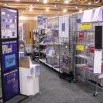 Trade show booth with display racks and signs.